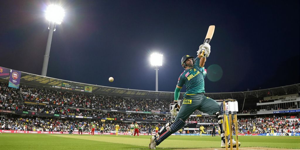 BBL cricket players in action at night stadium