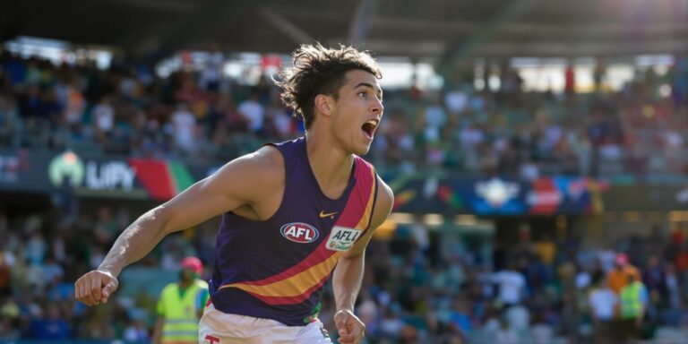 Young AFL player running on field during live match