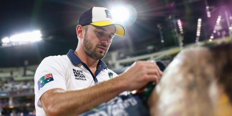 An Aussie physiotherapist treating a cricketer on a sunny field.