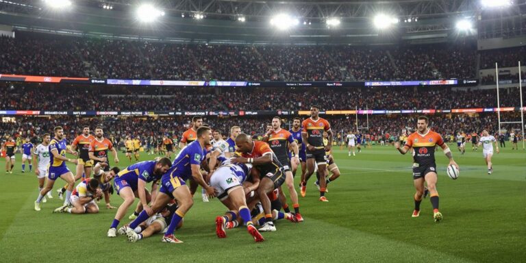 NRL players in action on stadium field with crowd