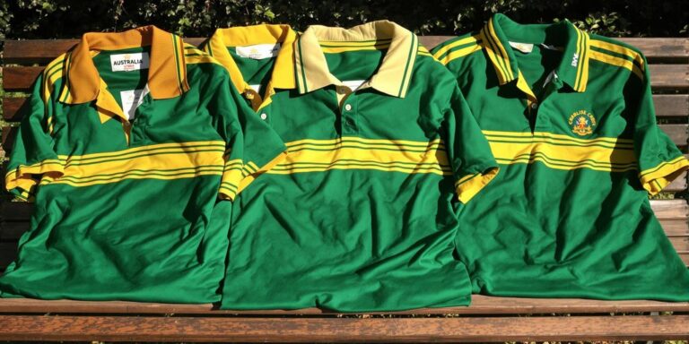 Classic retro Australian cricket shirts on wooden bench.