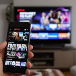Person using Netflix app on phone in living room