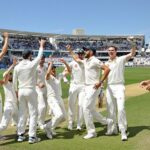 Australian cricketers celebrate wicket during Test match