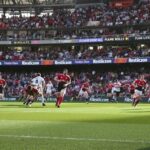 Rugby sevens players sprinting and diving during intense match