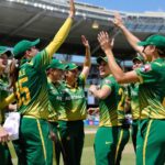 Australian women cricketers celebrating together on the field.