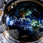 Astronaut floating with Earth in background.