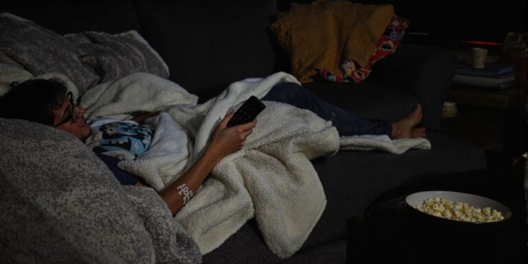Bloke relaxed, remote in hand, ready for a telly binge.