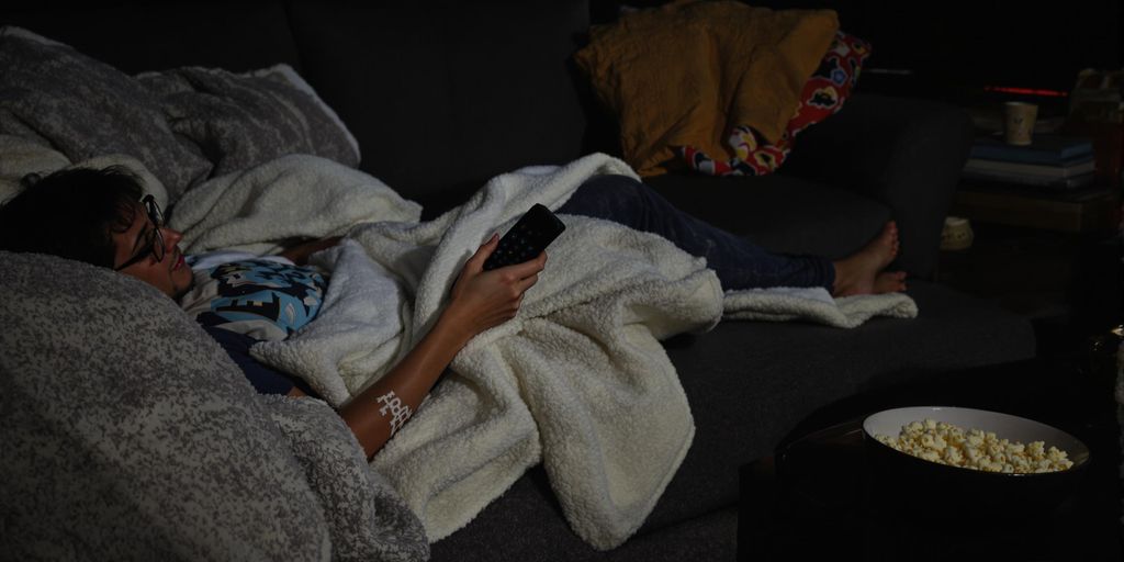 Bloke relaxed, remote in hand, ready for a telly binge.